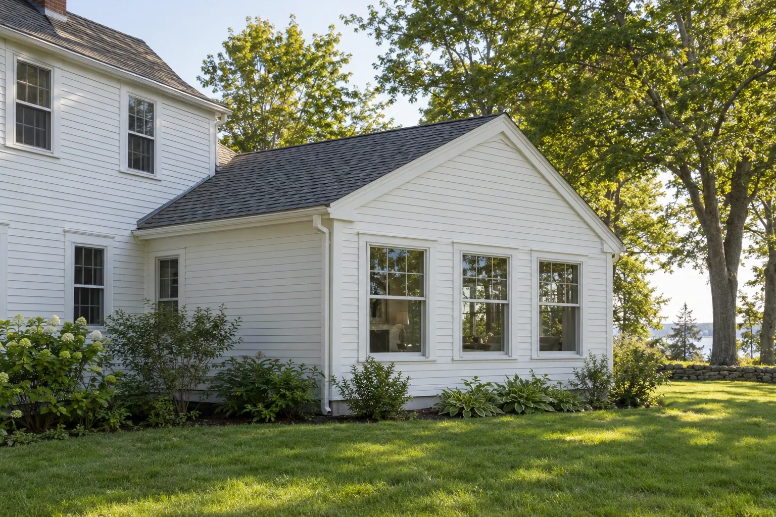 Finished single-story addition attached to a white clapboard Maine home